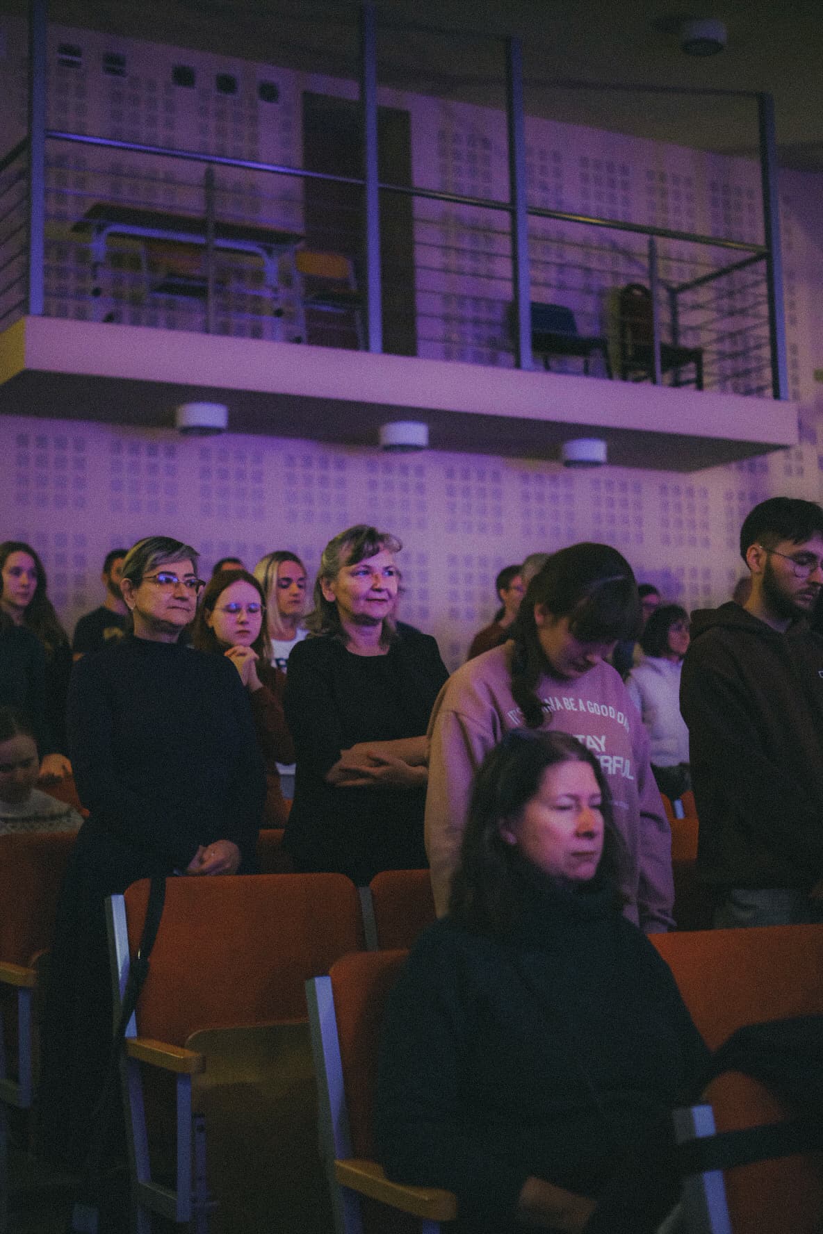 Grupka starszych i młodych ludzi razem modląca się do Boga. Osoby są ubrane w codzienne stroje